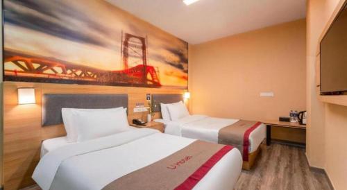 a hotel room with two beds and a painting on the wall at Thank Inn Hotel Jiangsu Wuxi High-Tech Zone Ruigang Pedestrian Street in Wuxi