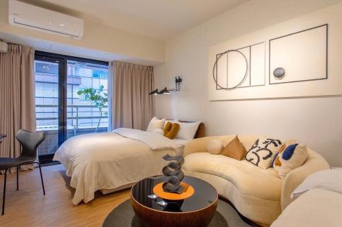 a room with two beds and a couch and a table at 樂居 台北 in T'ung-ko