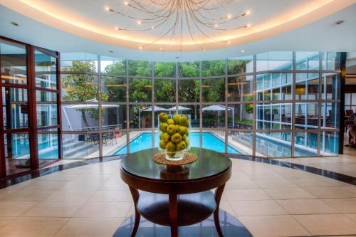 a bowl of fruit on a table in a building with a pool at City Lodge Hotel Bryanston in Johannesburg