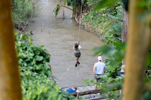 a person hanging from a rope over a river at NernJamsai in Sop Poeng