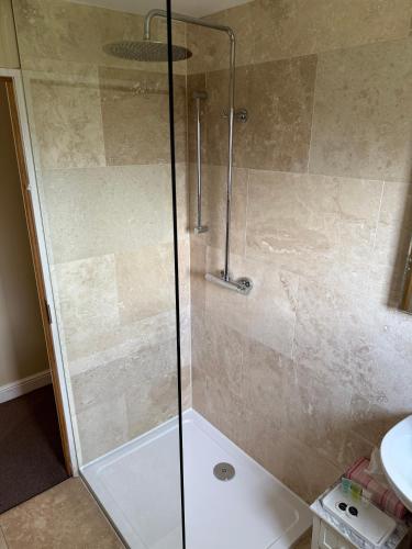 a shower with a glass door in a bathroom at The Star Inn Weaverthorpe in Weaverthorpe