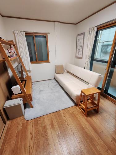 a living room with a white couch and a table at Oasis Aoto in Tokyo