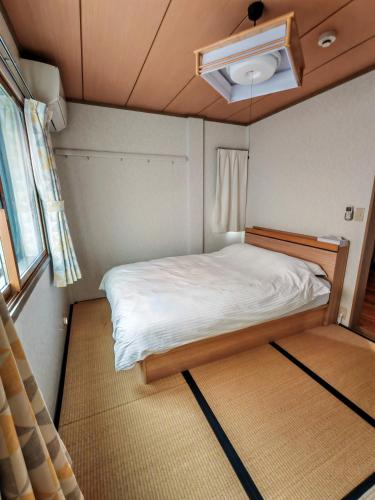 a small room with a bed and a window at Oasis Aoto in Tokyo
