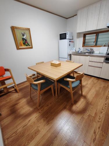 a kitchen with a wooden table and chairs in a room at Oasis Aoto in Tokyo