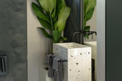 a bathroom with a potted plant on a wall at Predmet Babakan Canggu Bali in Dalung