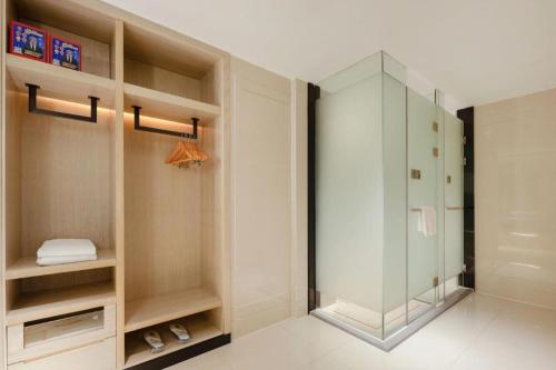 a bathroom with a glass shower in a room at Echarm Hotel Nanning the MixC Dongmeng Business District in Nanning