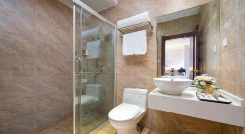 a bathroom with a toilet and a sink and a shower at Borrman Hotel Yuxi Yuxing Road in Yuxi