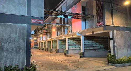 an empty parking lot outside of a building at night at Kidthuengpark in Si Racha