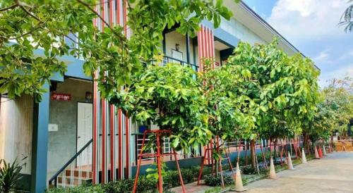 a building with a row of trees in front of it at Kidthuengpark in Si Racha