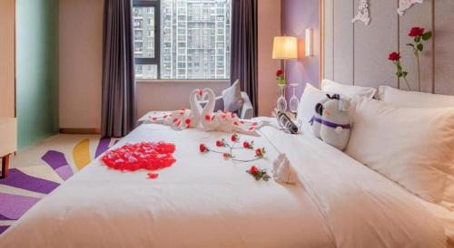 a white bed with flowers on top of it at Lavande Hotel Changsha South High-speed Railway Station Xiyingmen in Changsha