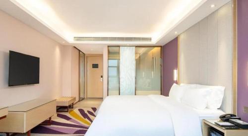 a hotel room with a bed and a television at Lavande Hotel Zhongshan Xiaolan Taifeng in Jilong