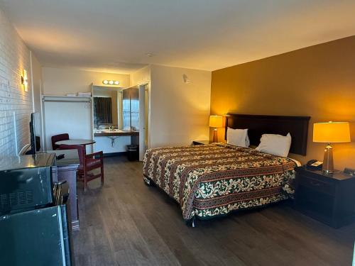 a hotel room with a bed and a desk at Economy Inn in Belleville