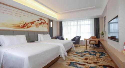 a hotel room with two beds and a desk at Vienna Hotel Chengdu University of Pertroleum Metro Station in Chengdu