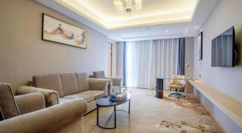 a living room with a couch and a table at Vienna Hotel Guangdong Zhongshan Xiaolan High-Speed Railway Station in Zhongshan