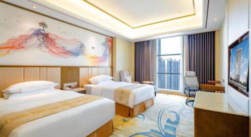 a hotel room with two beds and a large window at Venus Royal Hotel Nanning East High-Speed Railway Station in Nanning