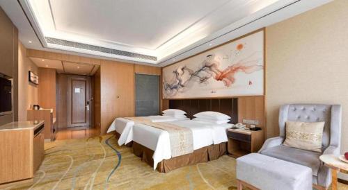 a hotel room with a large bed and a chair at Venus Royal Hotel Nanning East High-Speed Railway Station in Nanning