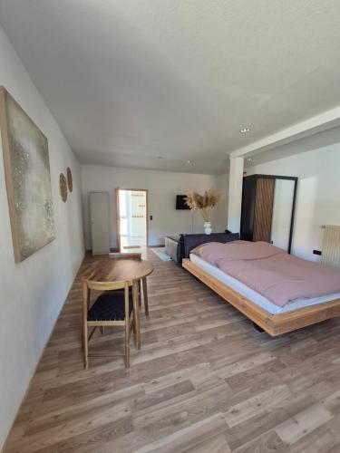 a bedroom with a bed and a wooden table at Apartment #1 in Olsbrücken