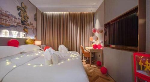 a hotel room with a large bed and a desk at Vienna Hotel Hangzhou East Railway Station West Square in Hangzhou