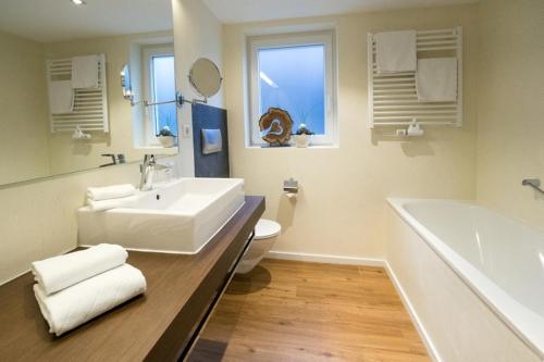 a bathroom with a sink and a tub and a toilet at Hotel Restaurant Der Engel, Sasbachwalden in Sasbachwalden