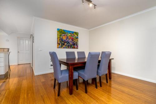 a dining room with a table and blue chairs at Spacious 2BR APT Panoramic Views Central Location - Hosted by CanStay in Narrabundah
