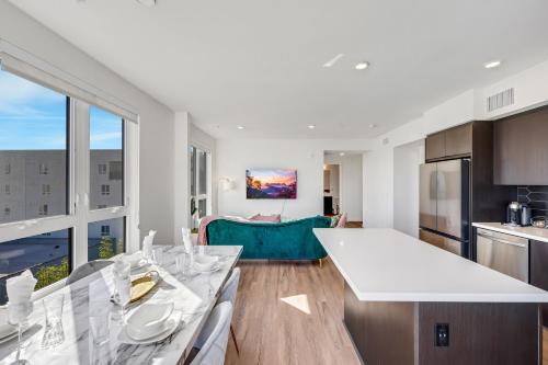 a kitchen and living room with a large white table at One Lux Stay - Hollywood in Los Angeles