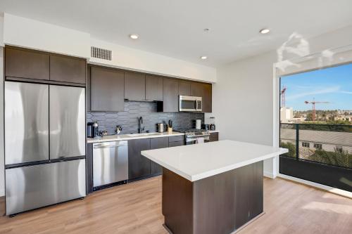 a kitchen with stainless steel appliances and a large window at One Lux Stay - Hollywood in Los Angeles