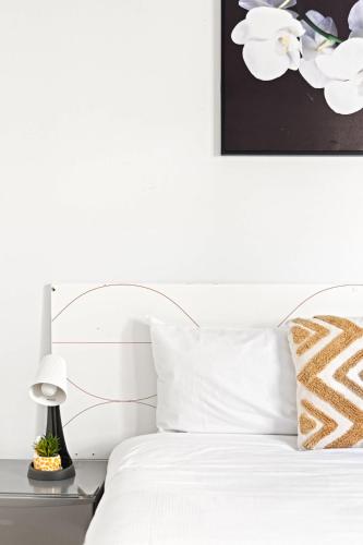 a bed with white sheets and a lamp on a table at Peaceful Stay in Lidcombe - Double Room on a Quiet Street - Shared Bathroom in Sydney