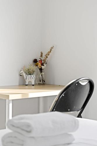 a table with a vase of flowers on a shelf at Peaceful Stay in Lidcombe - Double Room on a Quiet Street - Shared Bathroom in Sydney