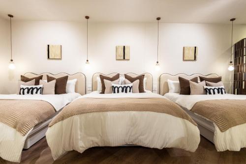 two beds in a room with white walls at 樂居 台北 in T'ung-ko