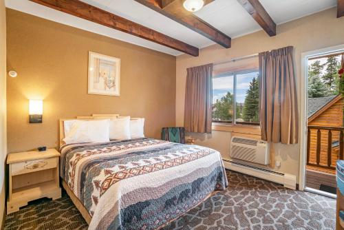 a bedroom with a bed and a large window at Spirit Lake Lodge in Grand Lake