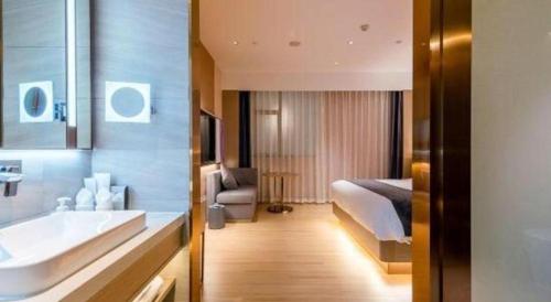 a bathroom with a sink and a bed and a tub at Borrman Hotel Zhongshan Lihe Plaza in Zhongshan