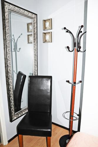 a black chair and a mirror in a room at Hotel Lamminpää in Tampere