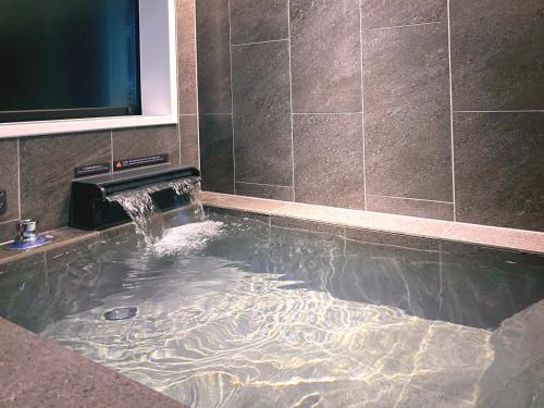 a bath tub with a water fountain in a bathroom at Rakuten STAY Hakone Susuki Grass Fields in Sengokuhara