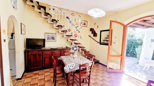 Un comedor con una mesa y una escalera. en Le Pleiadi - Casa Casoni, en Marcelli