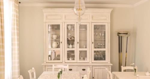 a white cabinet with glass doors in a dining room at Villa Modiva in Międzyzdroje