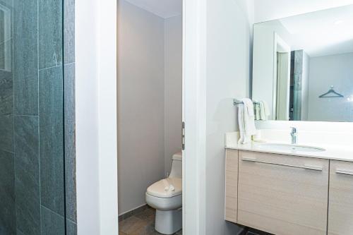 a bathroom with a toilet and a sink and a mirror at Elan at Ballena Beach in Uvita