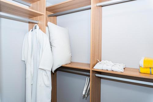 a closet with wooden shelves and white towels at Elan at Ballena Beach in Uvita