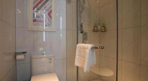 a bathroom with a shower with a toilet and a glass door at Borrman Hotel Guilin Railway Station Two Rivers and Four Lakes in Guilin