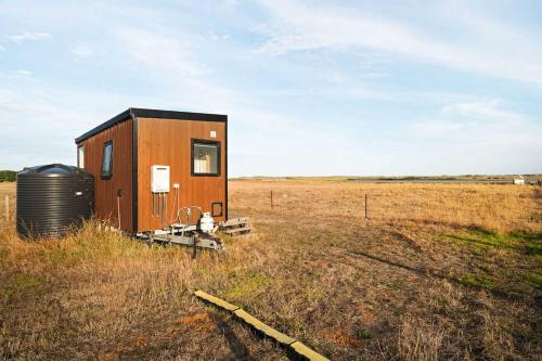 a small cabin in the middle of a field at Lough View Cabin by Tiny Away in Rosebrook