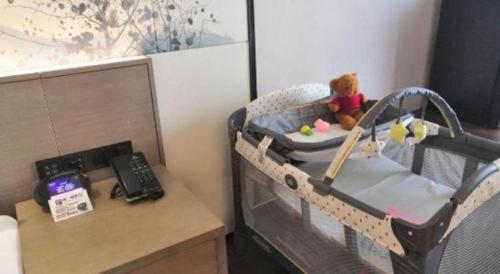 a baby crib with a teddy bear in it at Xiamen Seashine Lakeview Hotel in Xiamen