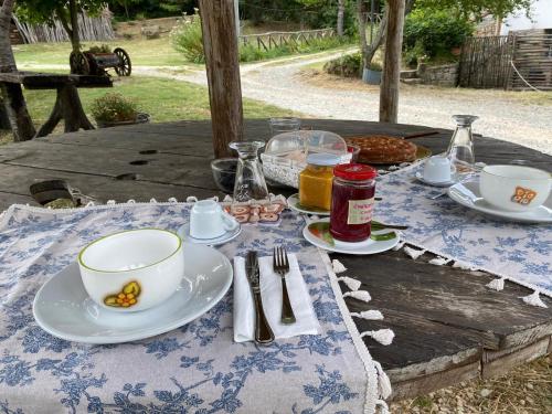 a table with plates and cups and utensils on it at Agriturismo Il Respiro del Bosco in San Piero in Bagno