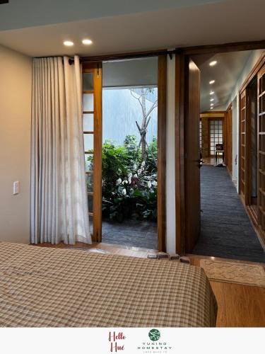 a bedroom with a bed and a sliding glass door at Yukino Homestay Vườn Ngôn Từ in Thôn Dương Xuân Hạ