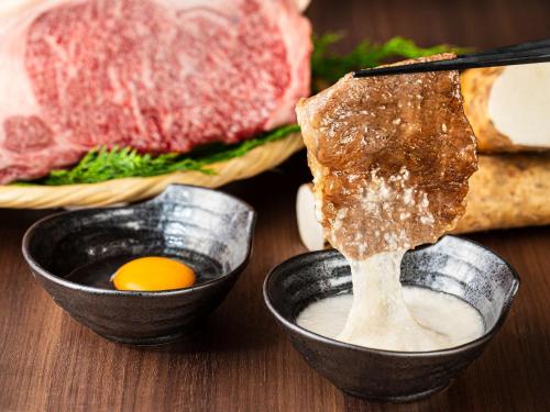 a table topped with bowls of food with meat and eggs at Rakuten STAY Hakone Susuki Grass Fields in Sengokuhara