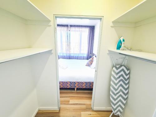 a small bedroom with a bed and a window at Exodus Dandenong Apartment Hotel in Dandenong