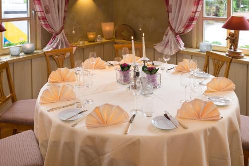 a table with a white table cloth and glasses on it at Hotel Restaurant Der Engel, Sasbachwalden in Sasbachwalden