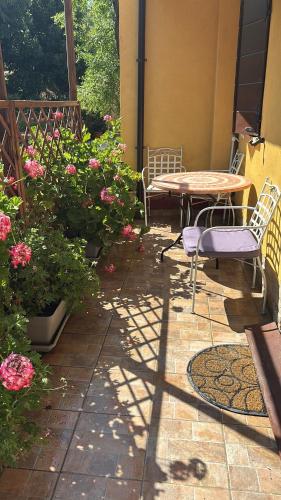 a patio with a table and chairs and flowers at Agriturismo Fattoria Del Colle By Enrico in Casa Cappanera