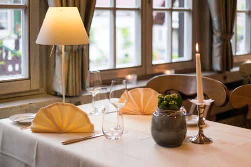 a table with a candle on a white table cloth at Hotel Restaurant Der Engel, Sasbachwalden in Sasbachwalden