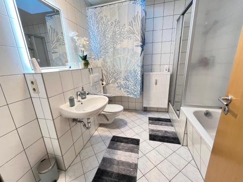 a bathroom with a sink and a toilet and a tub at Grill and Chill Terrasse, Dresden und Sächsische Schweiz erleben in Heidenau