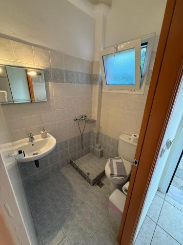 ein Badezimmer mit Toilette und Waschbecken in der Unterkunft Studios ΖΩΗ in Region Ilia