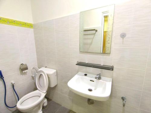 a bathroom with a toilet and a sink and a mirror at Lighthouse Tmn Intan 6pax Water Dispenser Neflix Target in Kluang